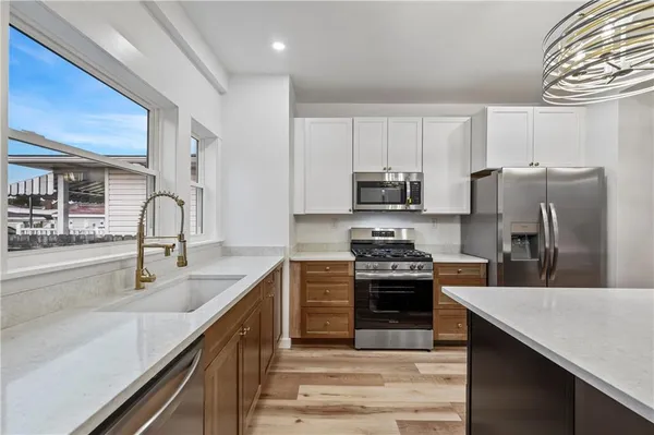 a kitchen with stainless steel appliances granite countertop a sink stove and refrigerator