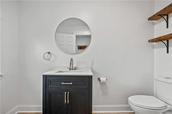 a bathroom with a toilet a sink and mirror