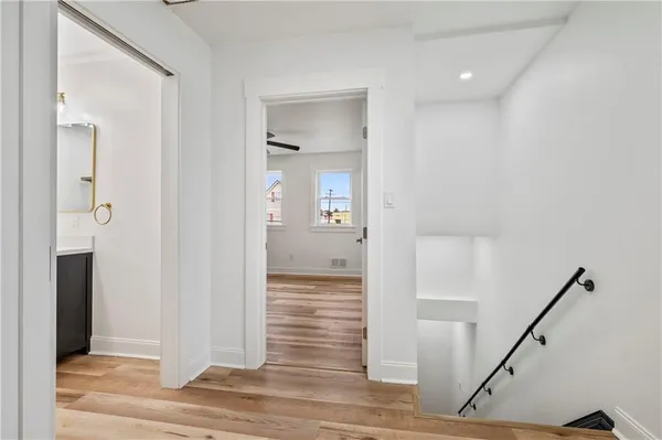 a view of a hallway with wooden floor and staircase