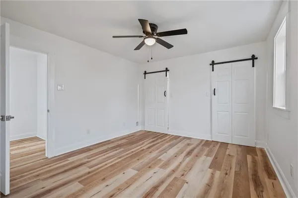 a view of empty room with wooden floor
