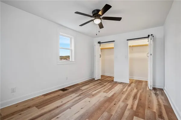 a view of empty room with wooden floor