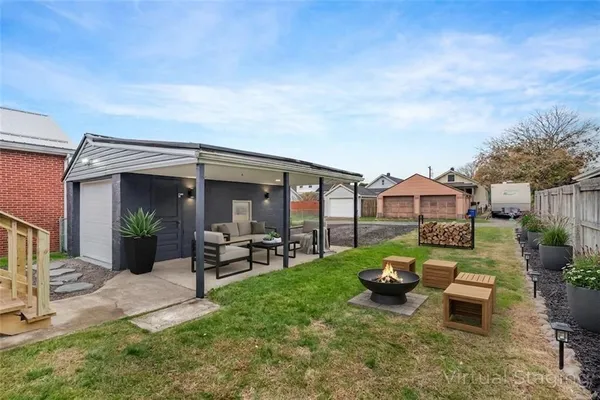 a view of a house with backyard sitting area and garden