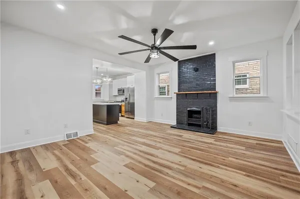 a view of a livingroom with a fireplace a ceiling fan and a fireplace