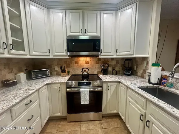 a view of a dining room with furniture a chandelier and wooden floor