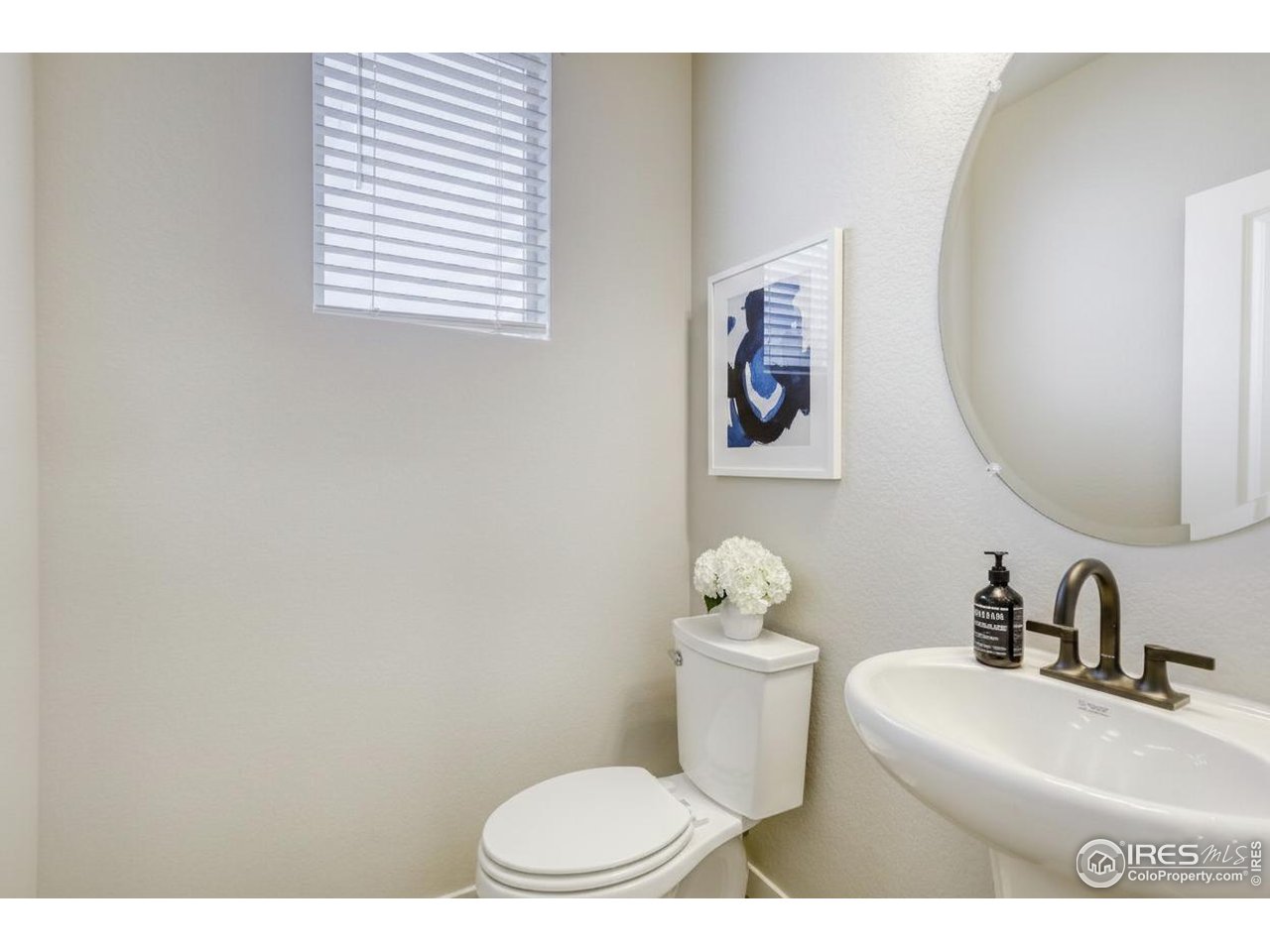 2367 East Suniga Road Fort Collins, CO 80524 - Photo 16 of 26 a bathroom with a toilet a sink and mirror