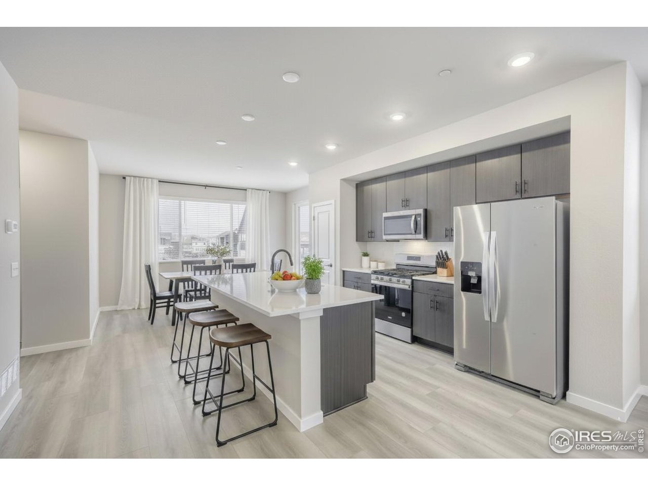 2367 East Suniga Road Fort Collins, CO 80524 - Photo 10 of 26 a kitchen with stainless steel appliances a refrigerator a stove a sink dishwasher with a dining table and chairs