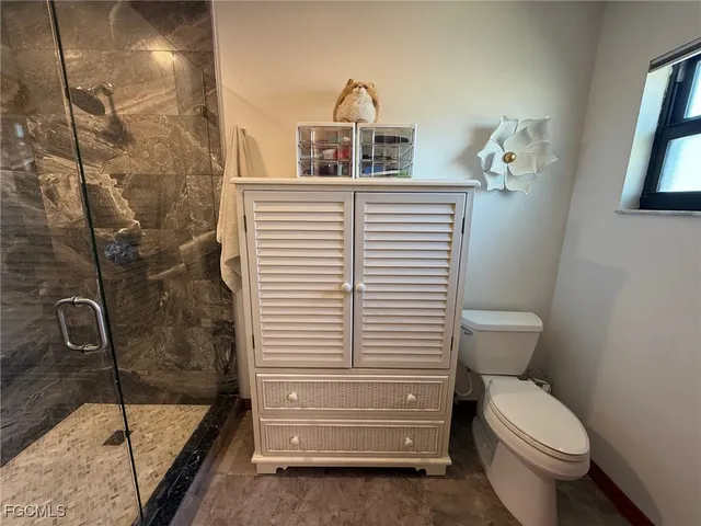 a bedroom with a bed bookshelf and a large window