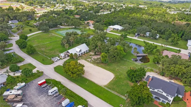 an aerial view of residential houses with outdoor space and trees