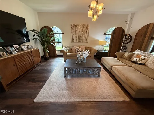 a living room with furniture flowerpot and a flat screen tv