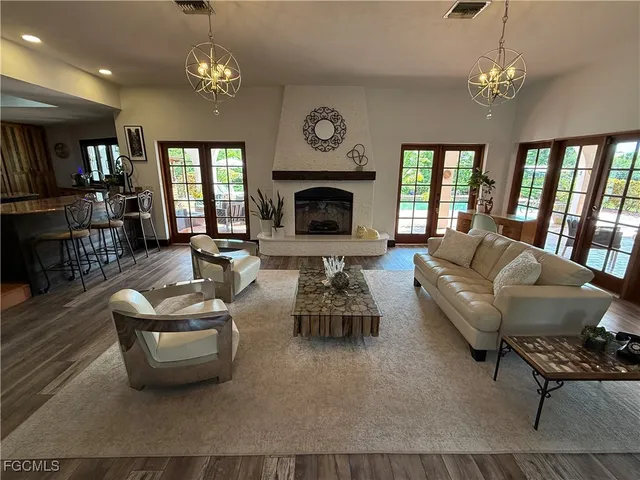 a living room with furniture a chandelier and a fireplace