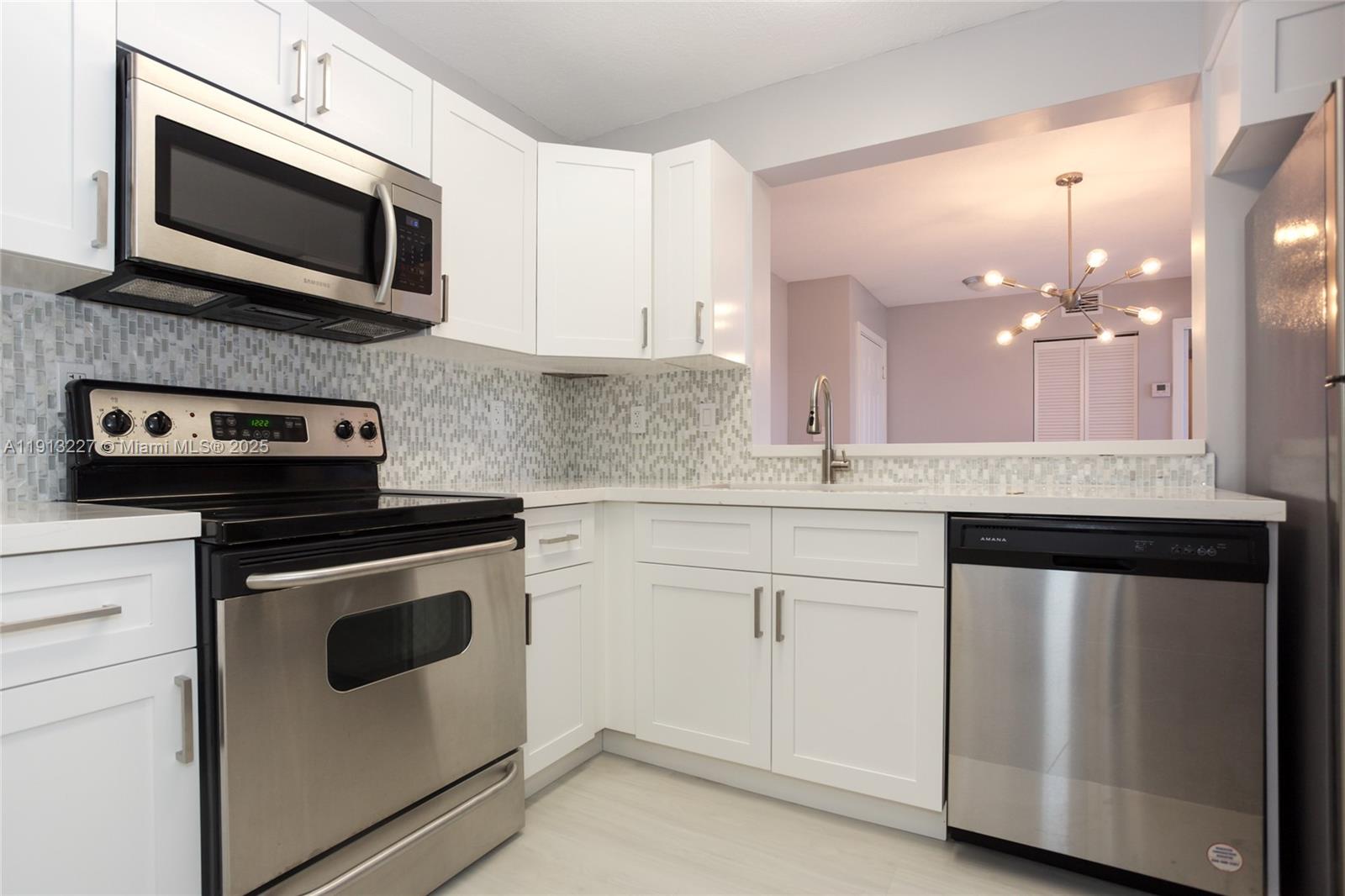 1350 Southeast 3rd Avenue, Unit 404 Dania Beach, FL 33004 - Photo 5 of 26 a kitchen with granite countertop cabinets stainless steel appliances and wooden floor