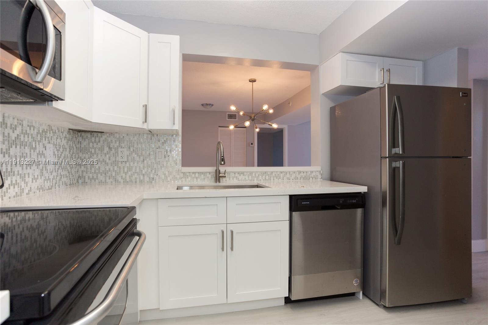 1350 Southeast 3rd Avenue, Unit 404 Dania Beach, FL 33004 - Photo 6 of 26 a kitchen with a sink stainless steel appliances and cabinets