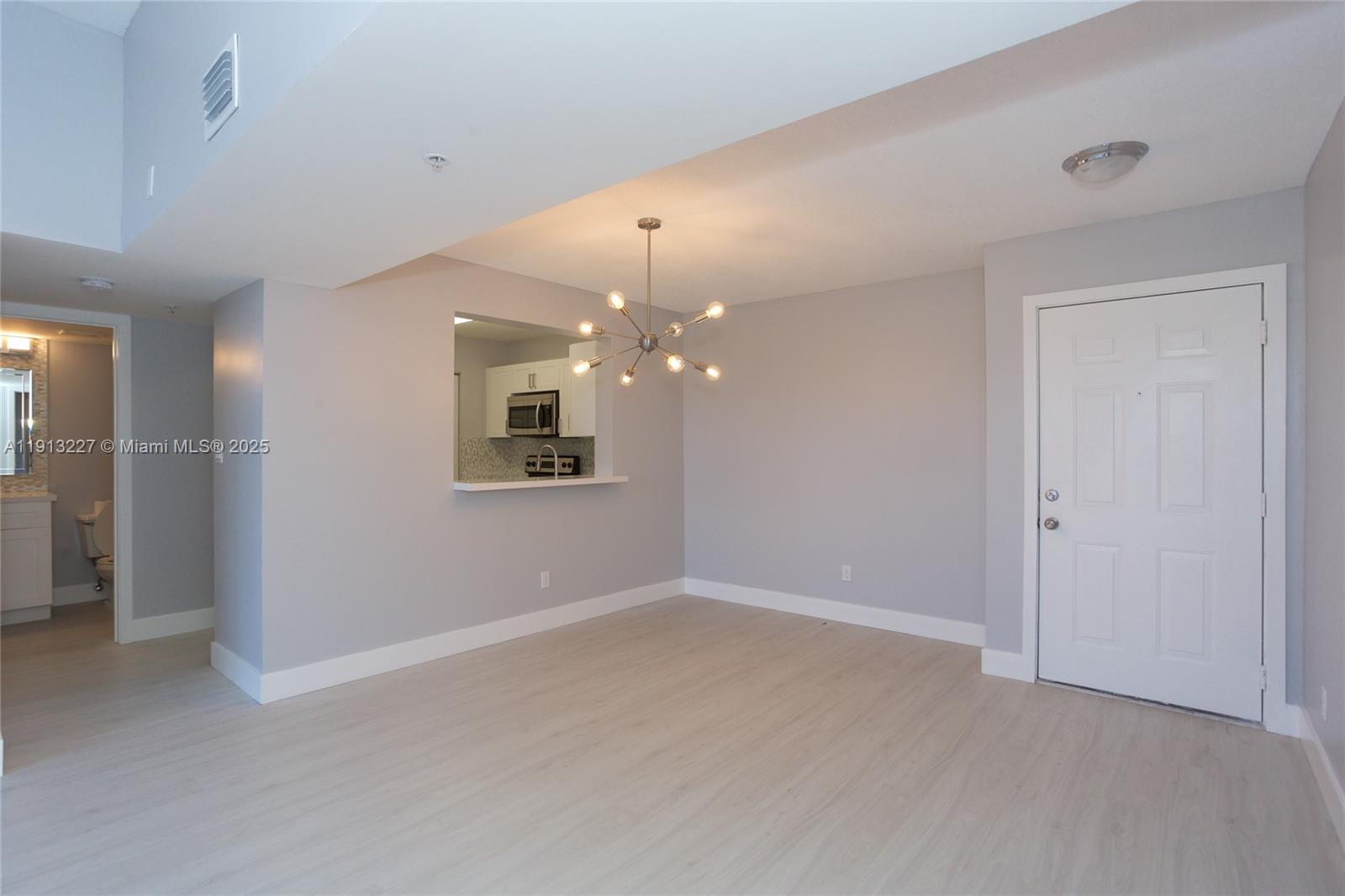 1350 Southeast 3rd Avenue, Unit 404 Dania Beach, FL 33004 - Photo 10 of 26 an empty room with chandelier fan and windows