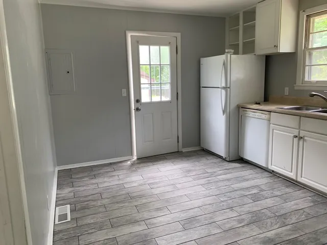 a view of a kitchen with wooden floor and electronic appliances