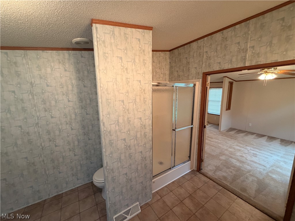 7213 Davis Road Orwell, OH 44076 - Photo 15 of 24 Bathroom featuring a shower with sliding glass doors, tile flooring, and patterned wall panels