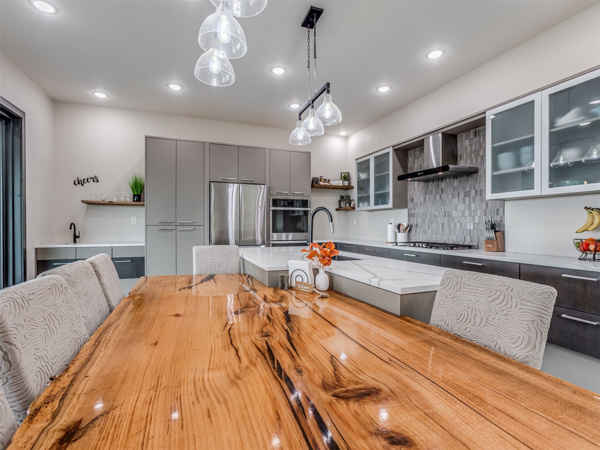 1073 Hidden Ridge Road Stigler, OK 74462 - Photo 22 of 56 Contemporary kitchen featuring a large wood-finish dining table, recessed lighting, a kitchen island with a white countertop, and a tiled backsplash