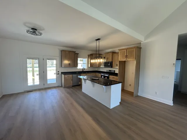 a kitchen with granite countertop a sink cabinets and wooden floor