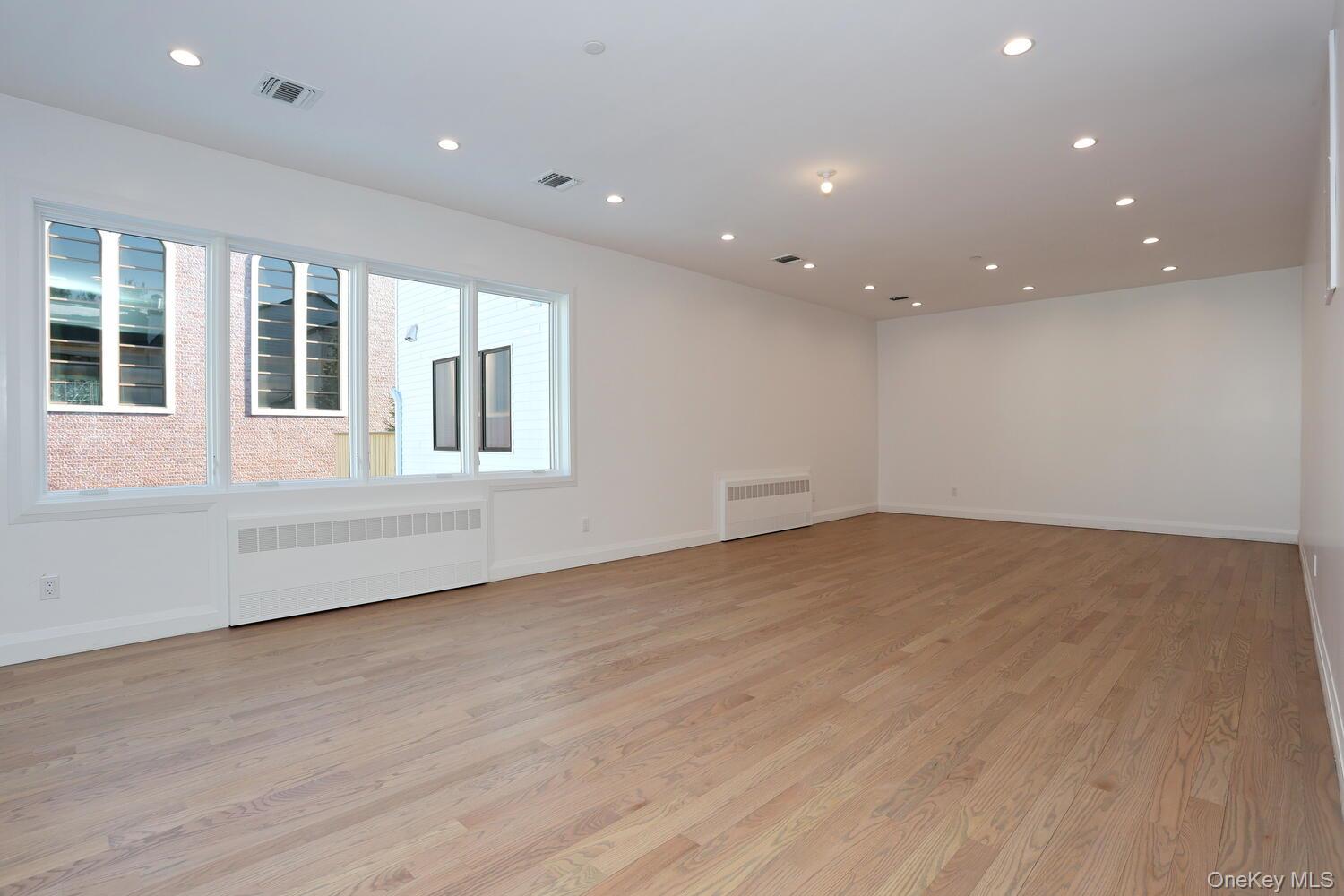 4 Howard Drive, Unit 213 Spring Valley, NY 10977 - Photo 16 of 42 an empty room with wooden floor and windows