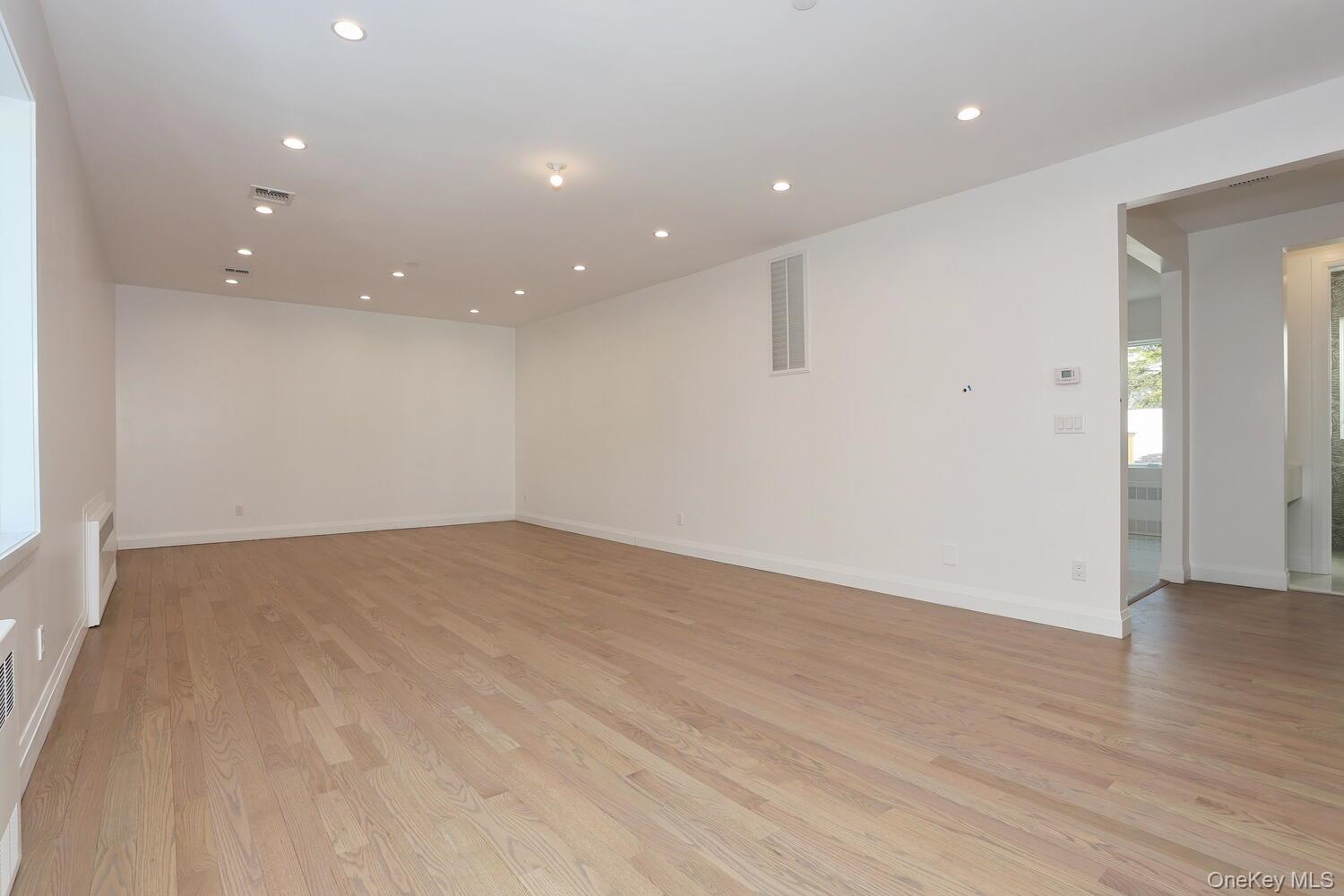 4 Howard Drive, Unit 213 Spring Valley, NY 10977 - Photo 17 of 42 an empty room with wooden floor and windows