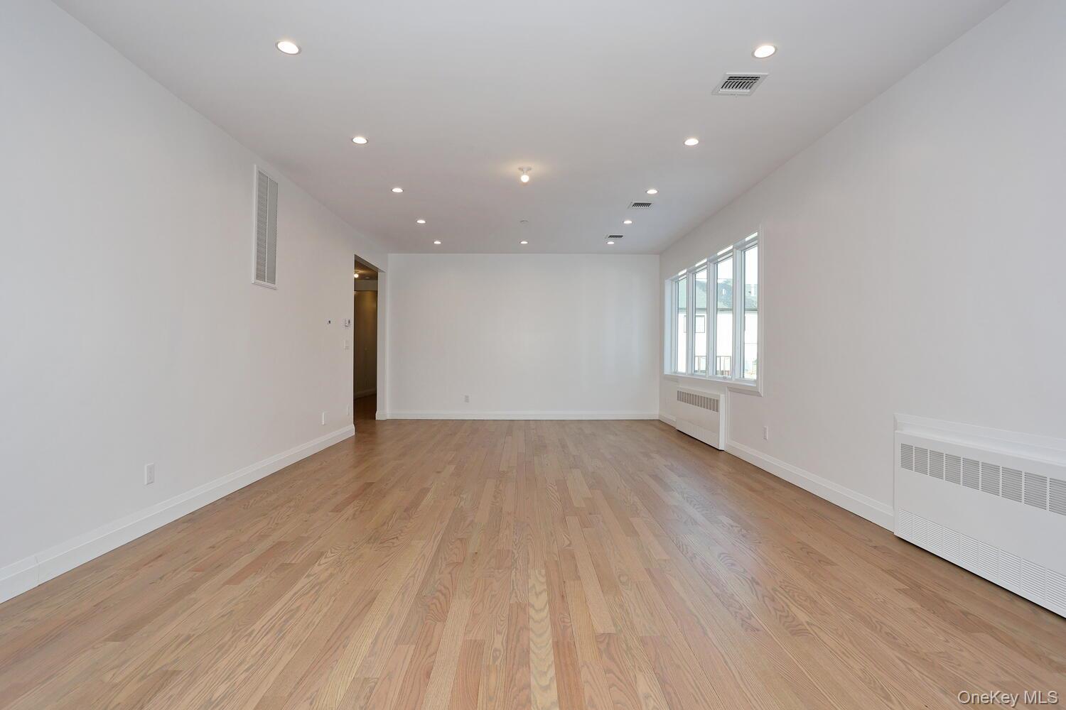 4 Howard Drive, Unit 213 Spring Valley, NY 10977 - Photo 18 of 42 an empty room with wooden floor and windows