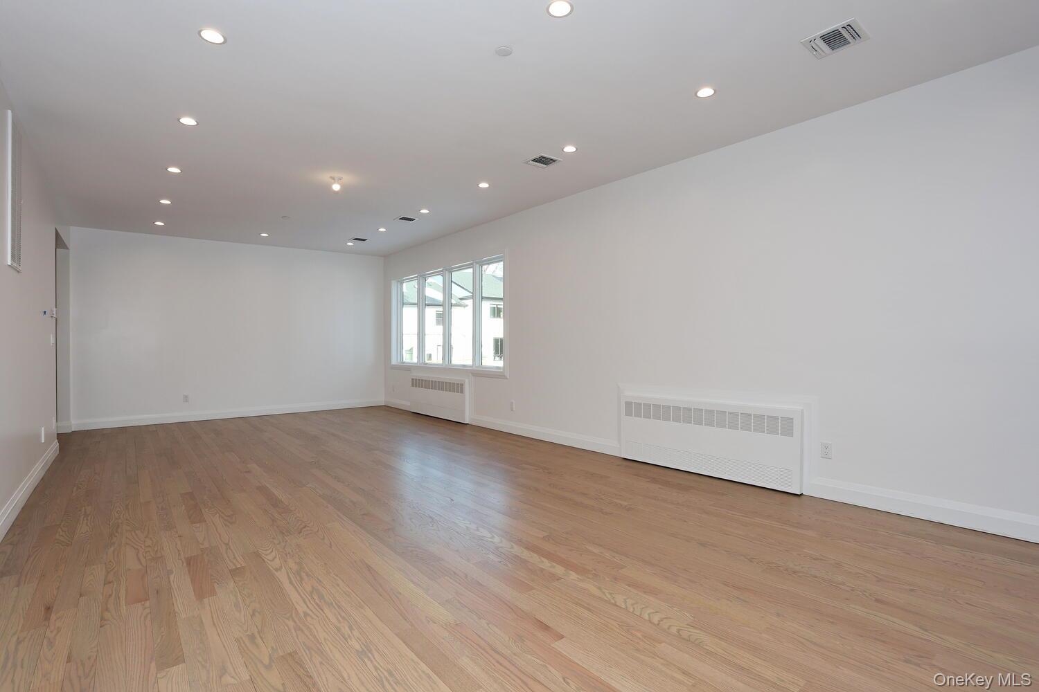 4 Howard Drive, Unit 213 Spring Valley, NY 10977 - Photo 19 of 42 an empty room with wooden floor and windows