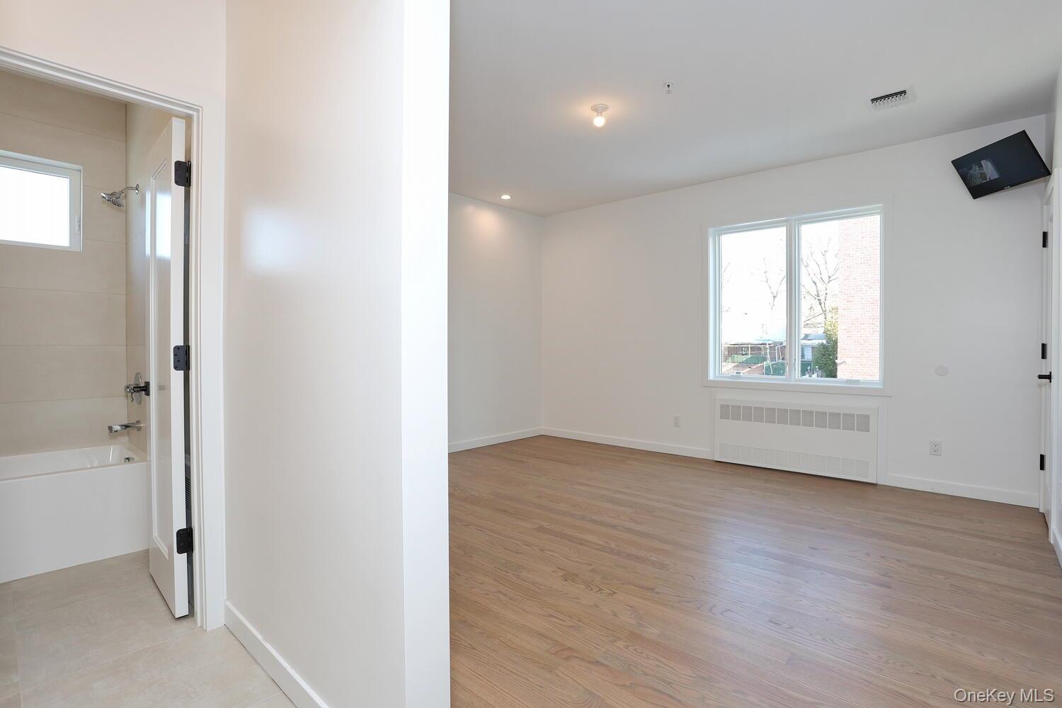 4 Howard Drive, Unit 213 Spring Valley, NY 10977 - Photo 24 of 42 a view of an empty room with wooden floor and a window