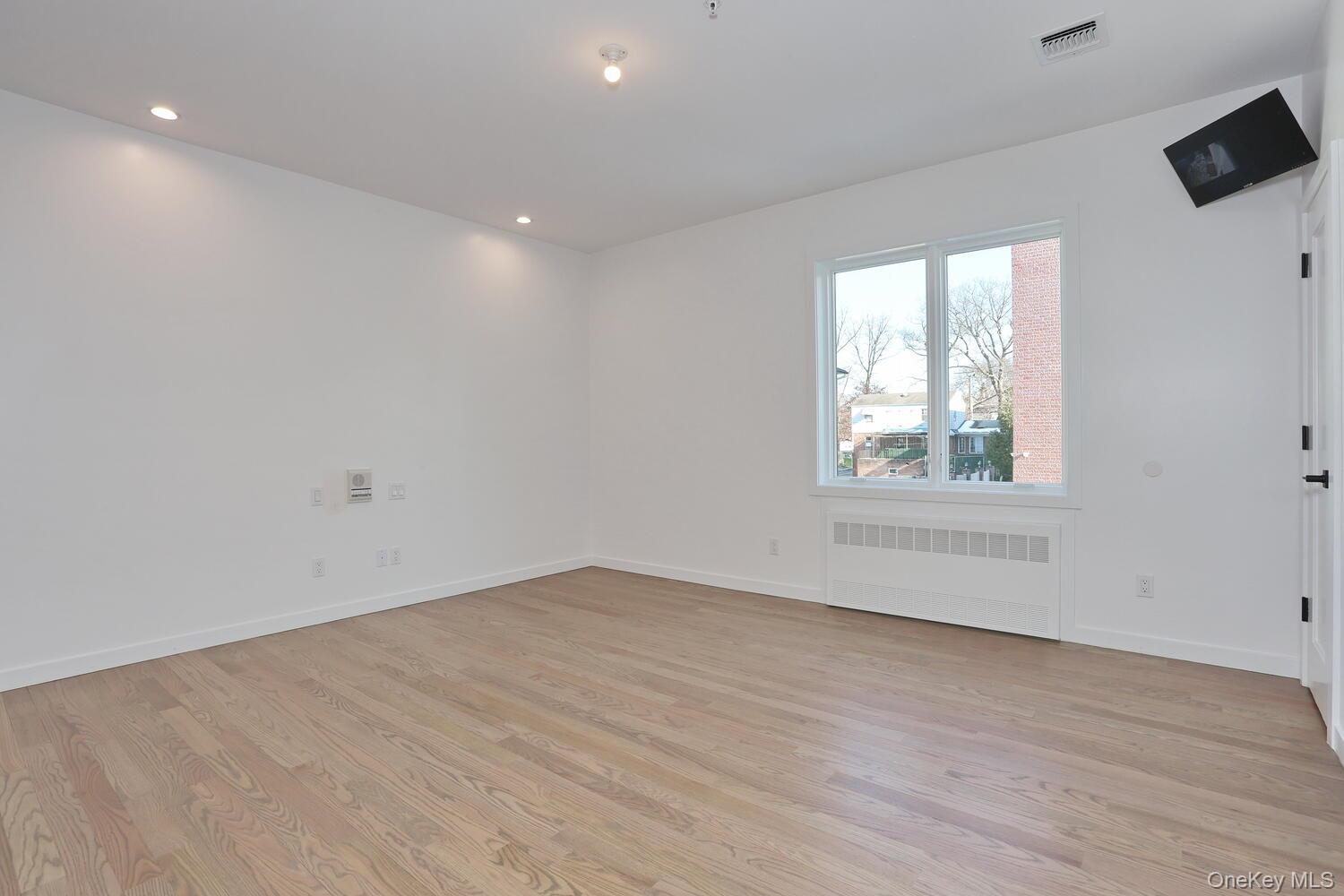 4 Howard Drive, Unit 213 Spring Valley, NY 10977 - Photo 25 of 42 an empty room with wooden floor and windows