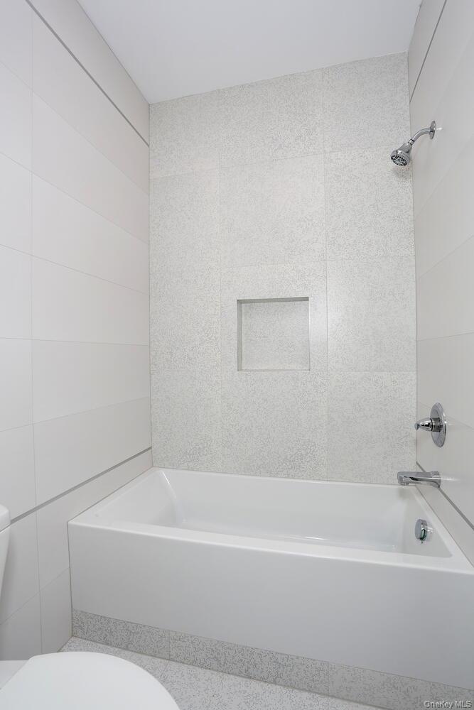 4 Howard Drive, Unit 213 Spring Valley, NY 10977 - Photo 34 of 42 a bathroom with a bathtub and a shower