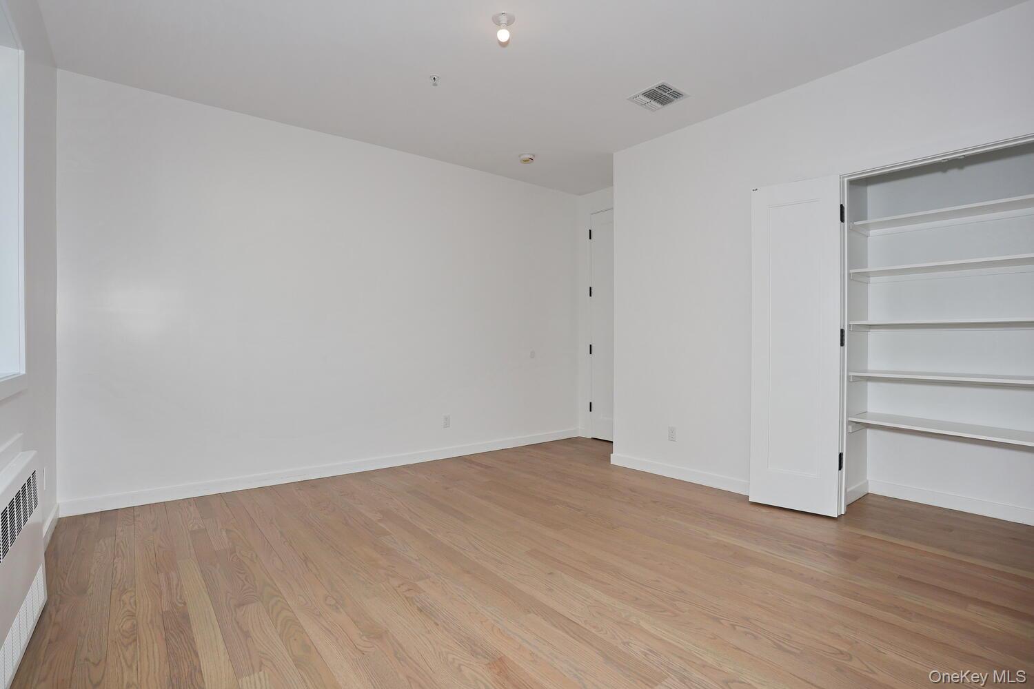 4 Howard Drive, Unit 213 Spring Valley, NY 10977 - Photo 37 of 42 a view of an empty room with wooden floor and closet