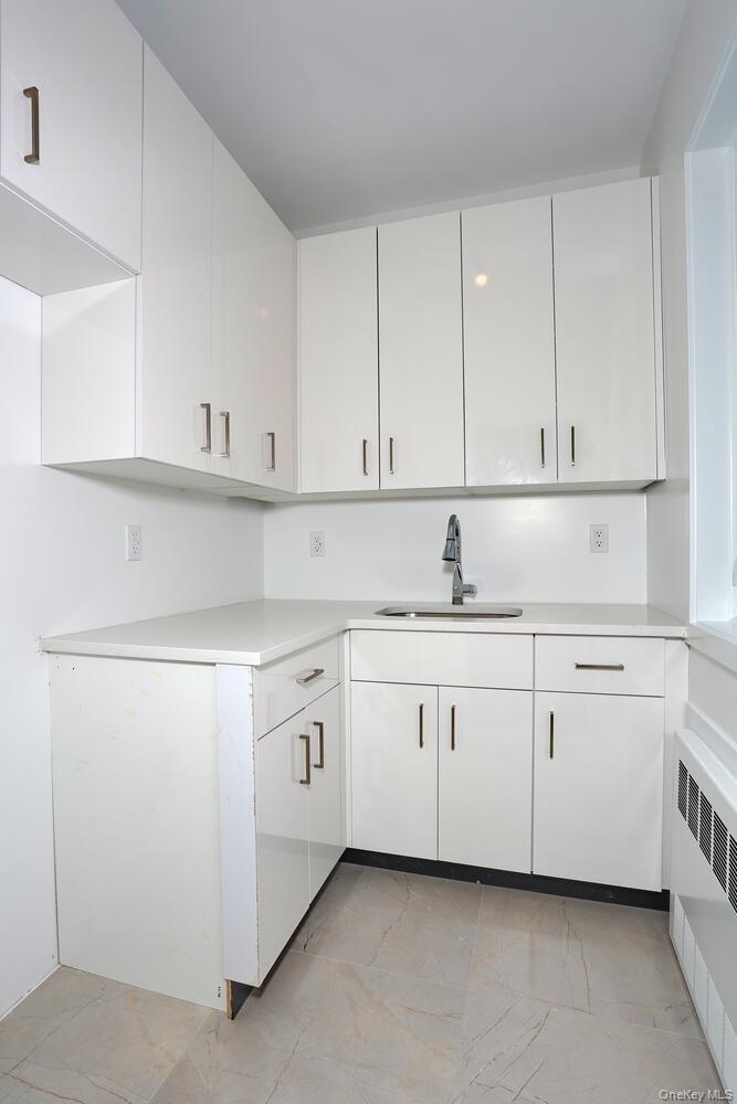 4 Howard Drive, Unit 213 Spring Valley, NY 10977 - Photo 39 of 42 a kitchen with white cabinets and white appliances
