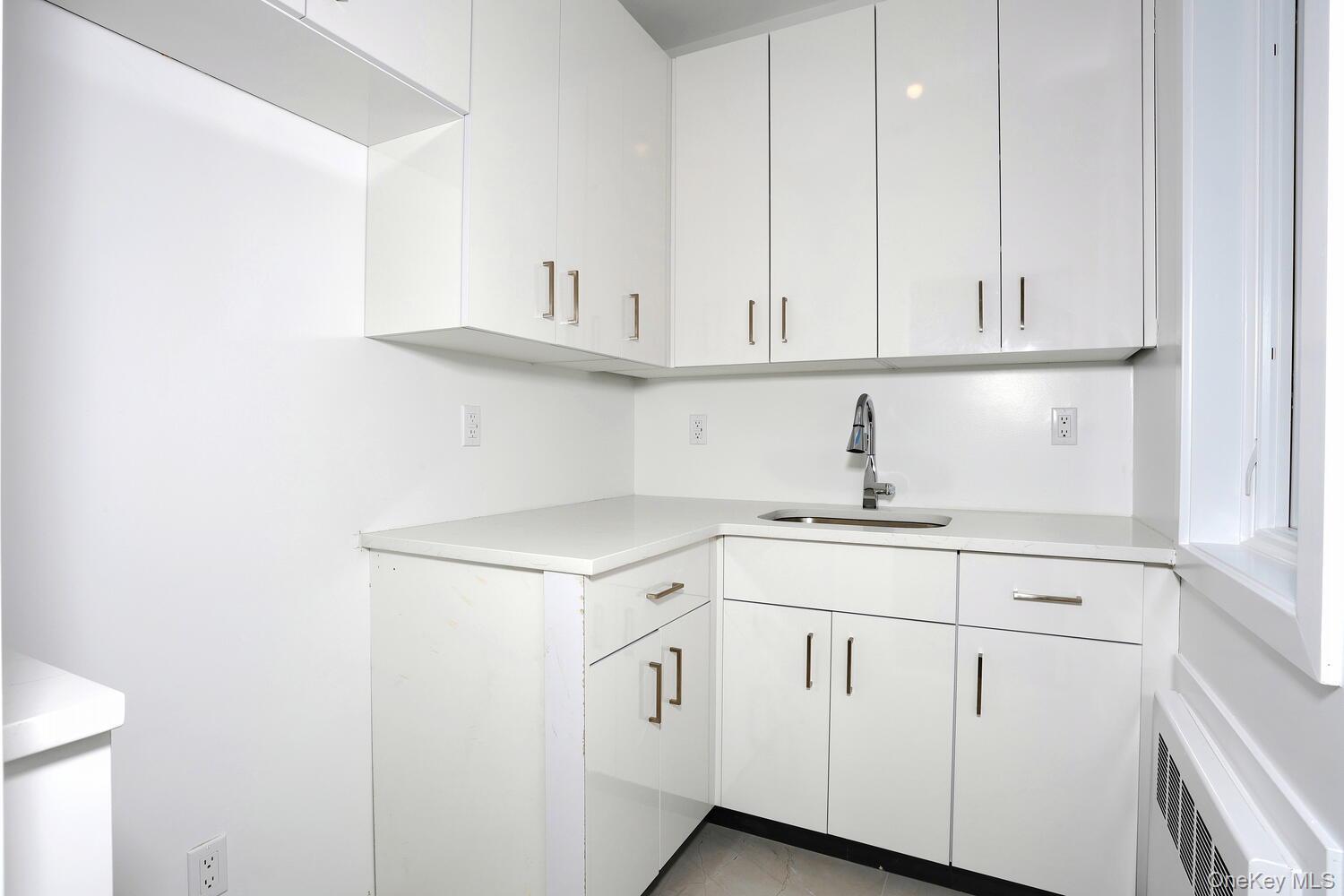 4 Howard Drive, Unit 213 Spring Valley, NY 10977 - Photo 40 of 42 a kitchen with white cabinets and a sink