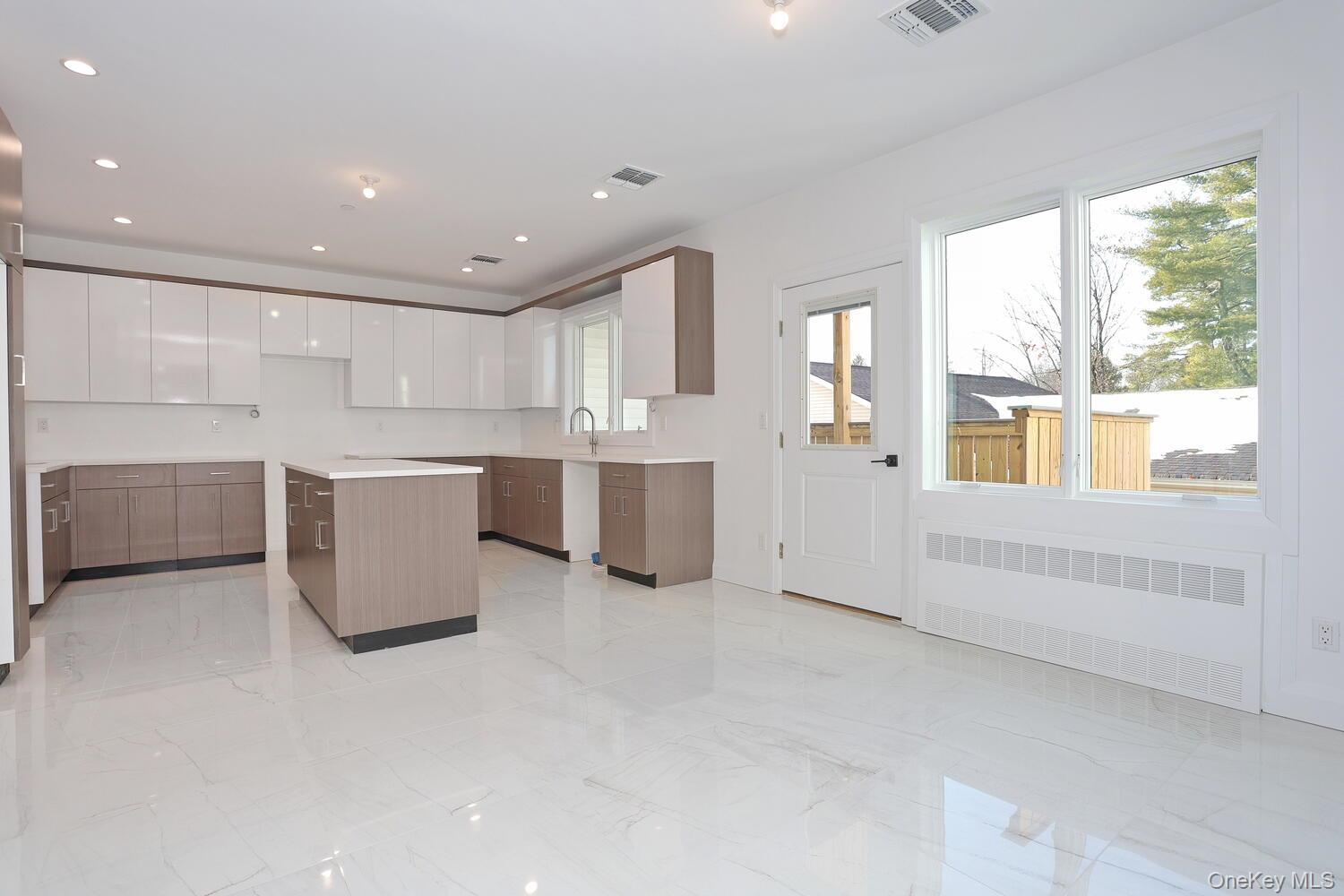4 Howard Drive, Unit 213 Spring Valley, NY 10977 - Photo 5 of 42 a large white kitchen with stainless steel appliances granite countertop a large window and a refrigerator