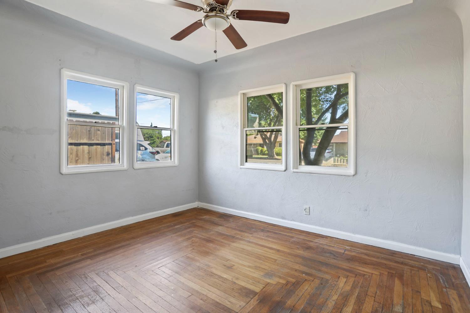 916 Elm Avenue Modesto, CA 95351 - Photo 20 of 52 21. Bedroom with four windows Sunlight on two sides, hardwood floors underfoot, and just enough vintage charm to make this room feel quietly special.