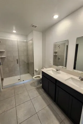 a bathroom with a double vanity sink toilet and shower