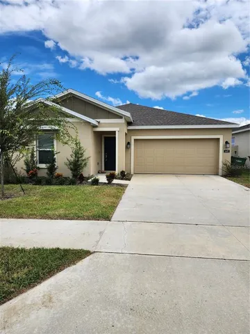 a front view of a house with a yard and a garage