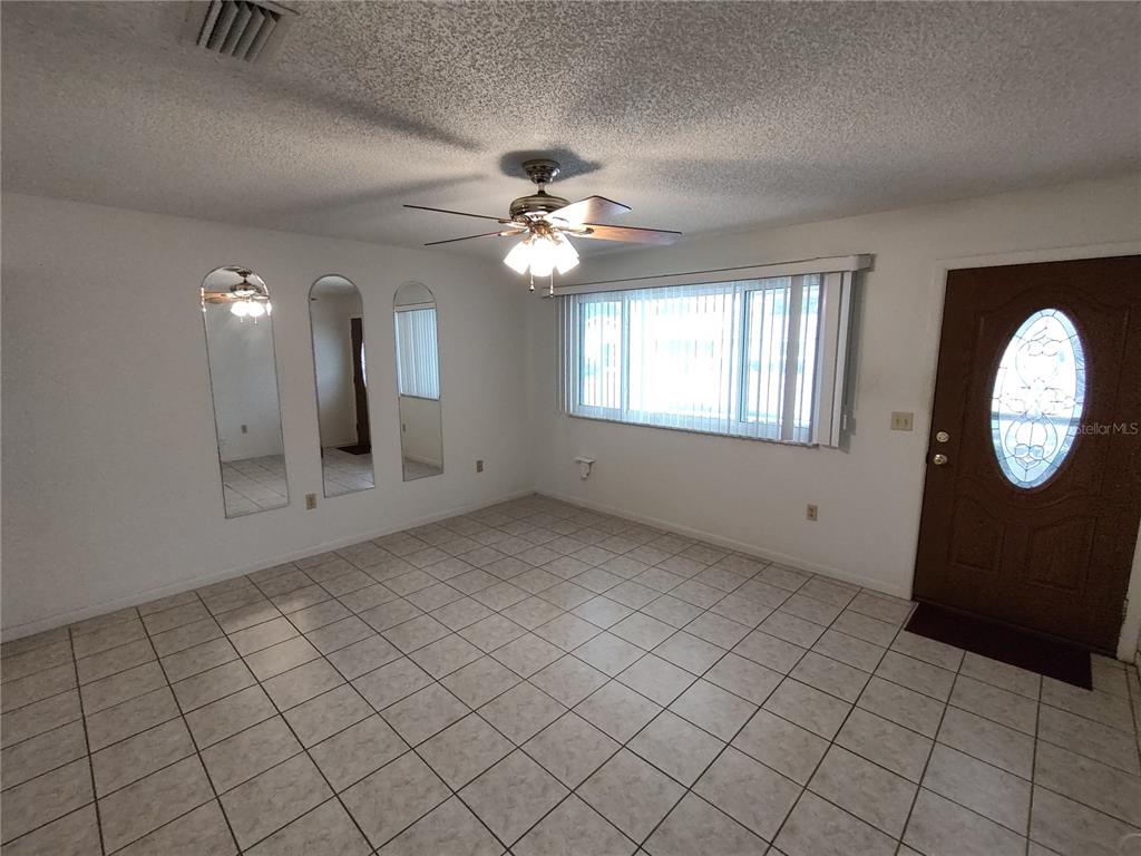 8565 Southwest 109th Street Ocala, FL 34481 - Photo 5 of 27 an empty room with windows and fan