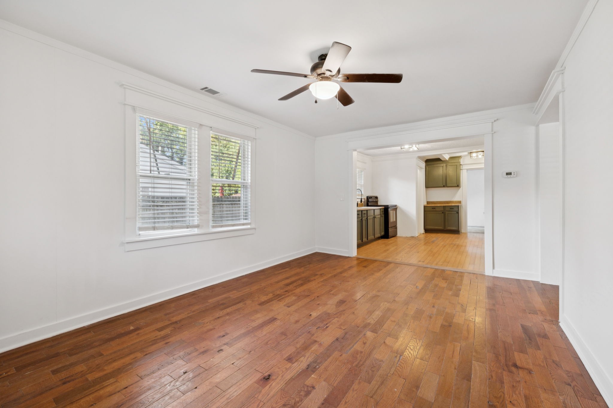 1008 Bales Street Gallatin, TN 37066 - Photo 3 of 19 a big room with wooden floor a ceiling fan and windows