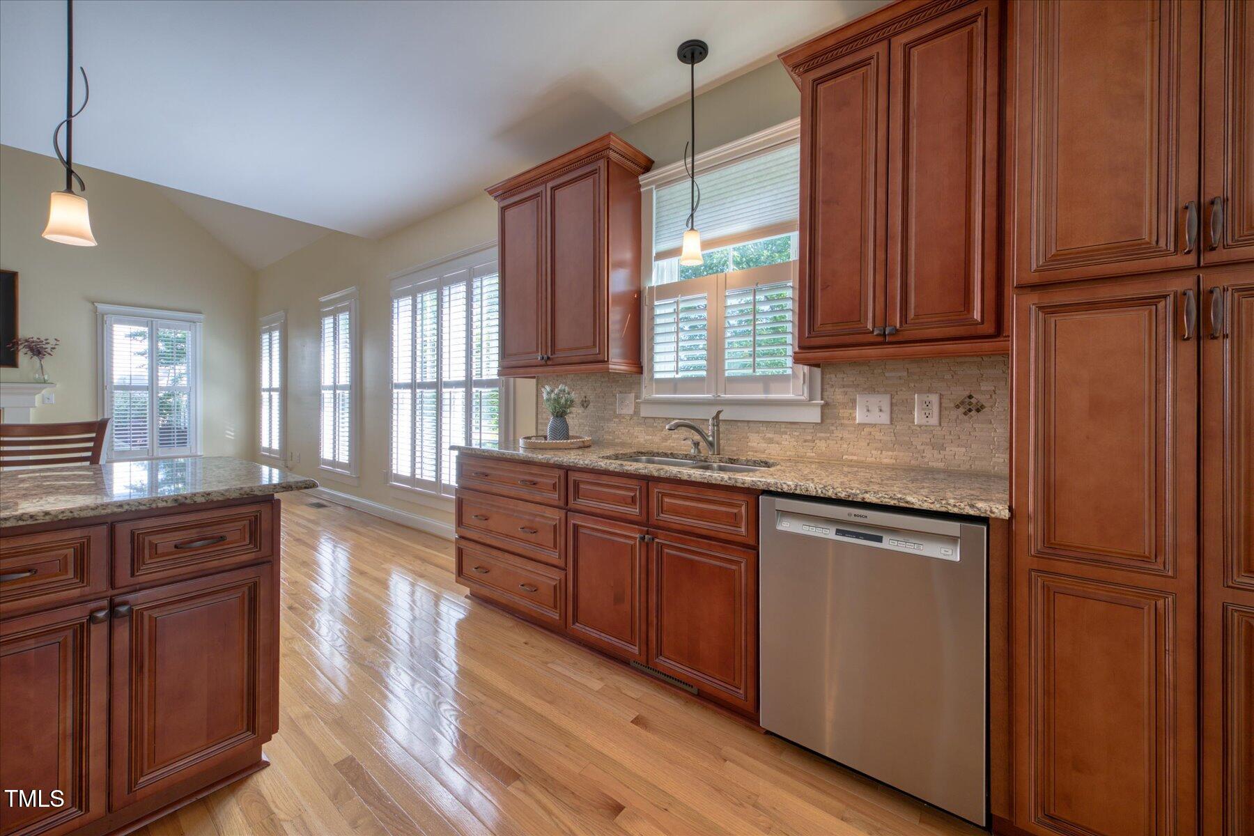 121 Bridgegate Drive Cary, NC 27519 - Photo 8 of 38 a kitchen with granite countertop wooden cabinets stainless steel appliances a sink and a window