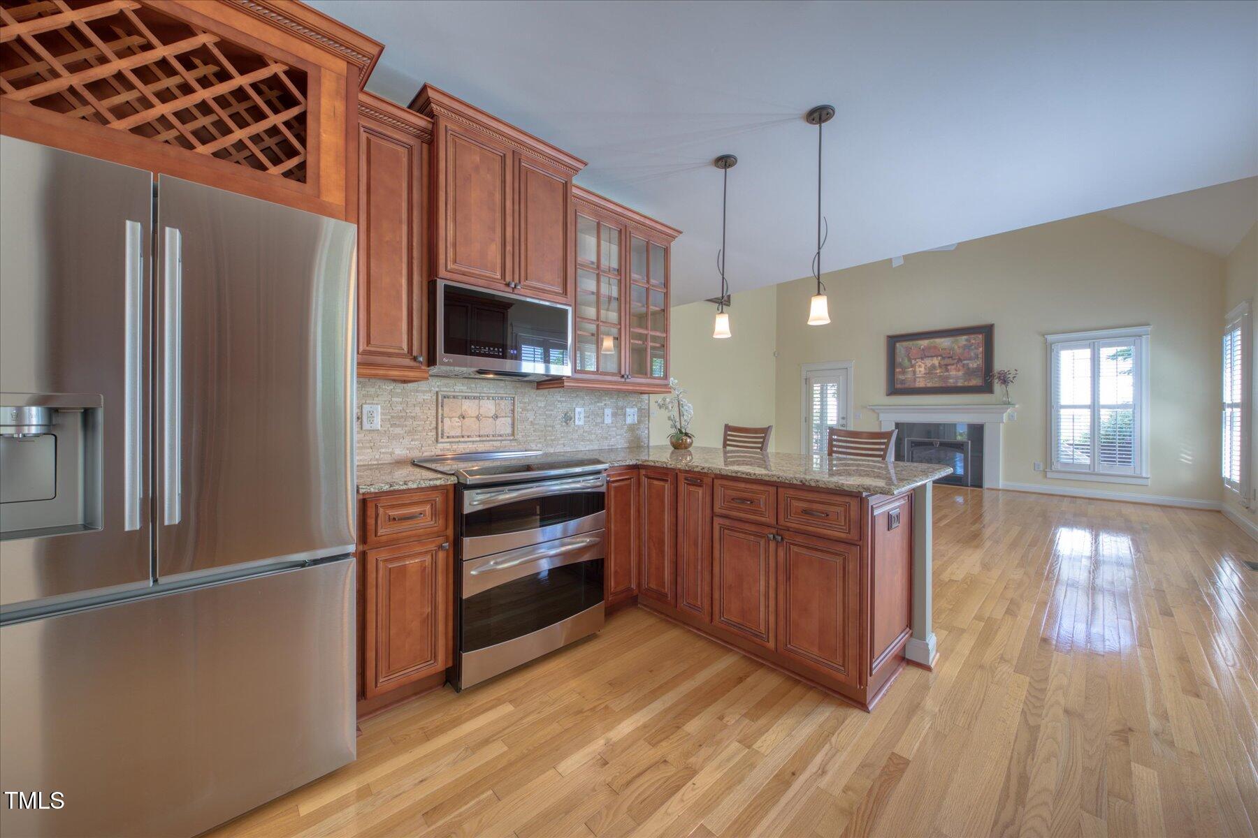 121 Bridgegate Drive Cary, NC 27519 - Photo 9 of 38 a kitchen with stainless steel appliances granite countertop a refrigerator a stove top oven a sink dishwasher and wooden floor