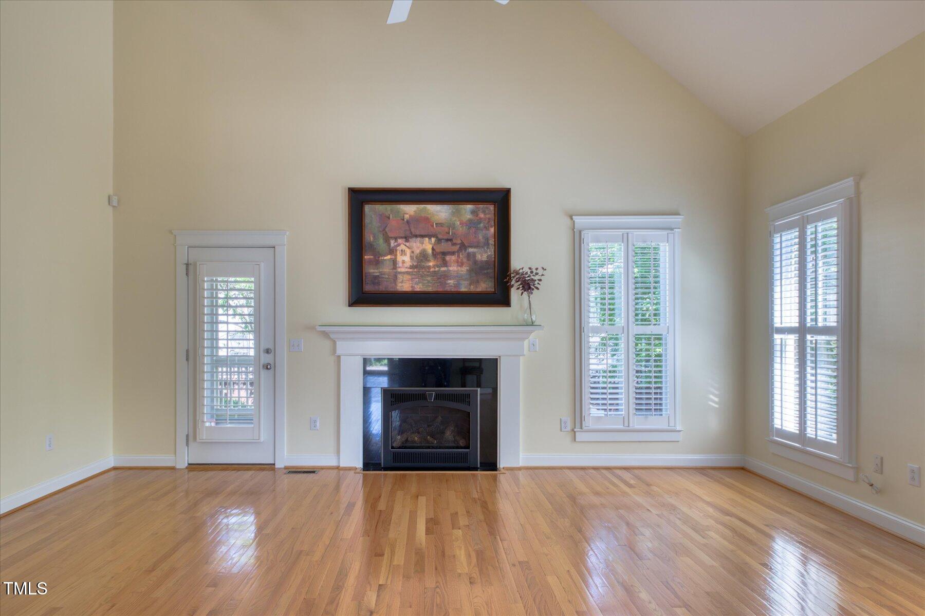 121 Bridgegate Drive Cary, NC 27519 - Photo 12 of 38 an empty room with windows fireplace and wooden floor
