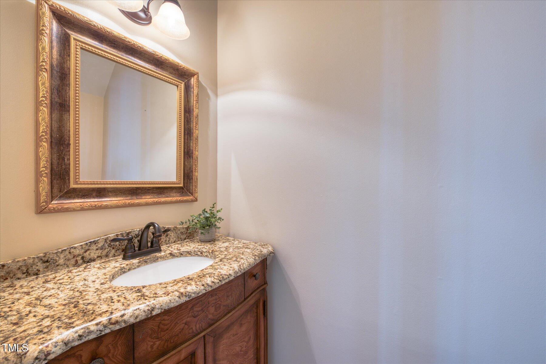 121 Bridgegate Drive Cary, NC 27519 - Photo 13 of 38 a bathroom with a granite countertop sink and a mirror