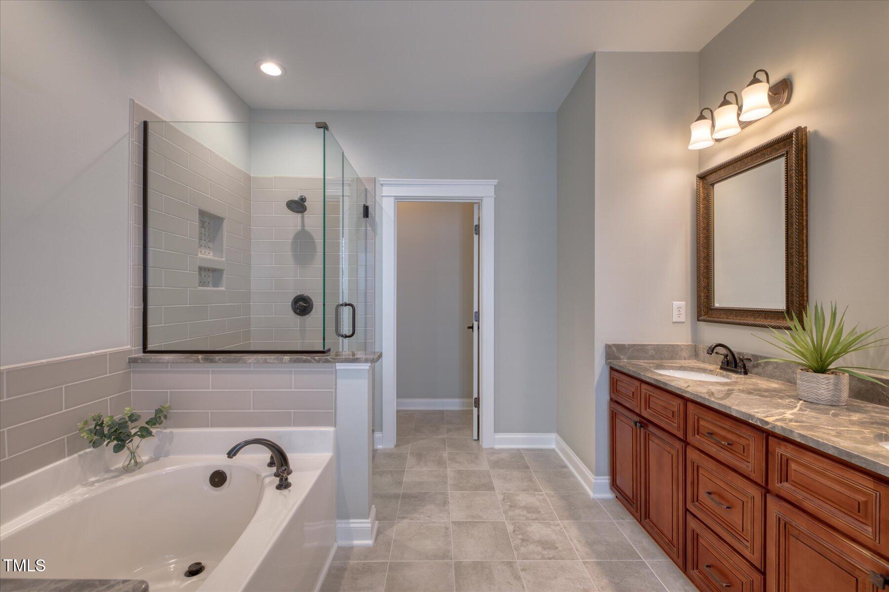 121 Bridgegate Drive Cary, NC 27519 - Photo 16 of 38 a bathroom with a tub sink and mirror