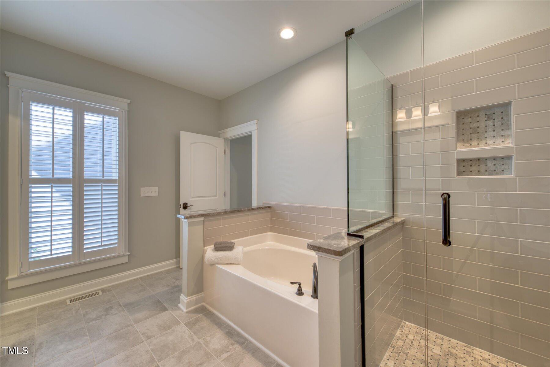 121 Bridgegate Drive Cary, NC 27519 - Photo 17 of 38 a bathroom with a tub a sink and a shower