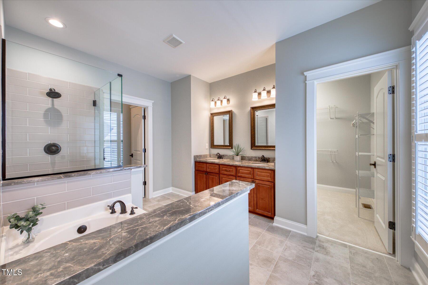 121 Bridgegate Drive Cary, NC 27519 - Photo 18 of 38 a spacious bathroom with a granite countertop sink mirror and shower