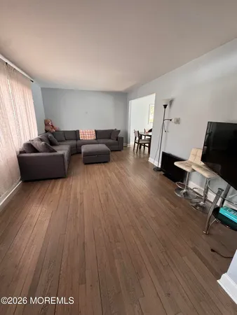 a living room with furniture and a wooden floor