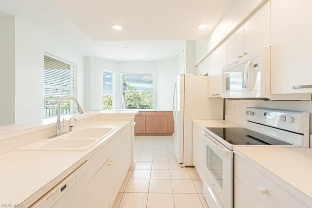 a kitchen with white cabinets and white appliances