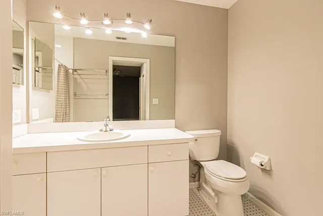 a bathroom with a sink a toilet a mirror and shower