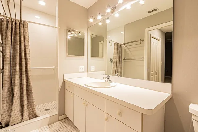 a bathroom with a double vanity sink a mirror and a shower