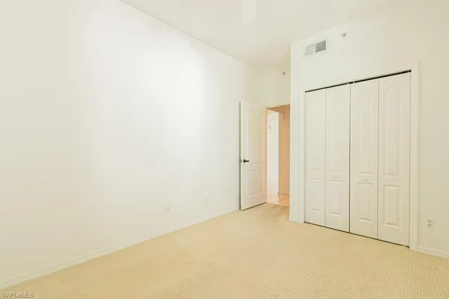 an empty room with a window and a ceiling fan