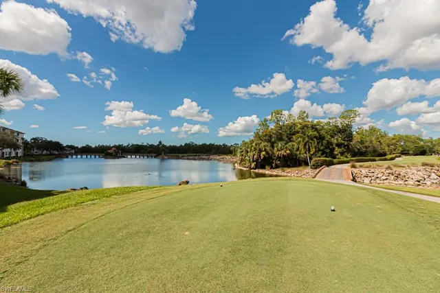 a view of a white house with a yard and a fountain